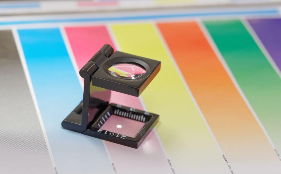 magnifier-printer-loupe-sits-colorful-test-sheet magnifier printer loupe sits colorful test sheet